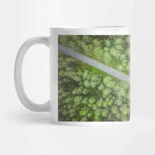 Empty road going diagonally through the forest top down aerial view Mug